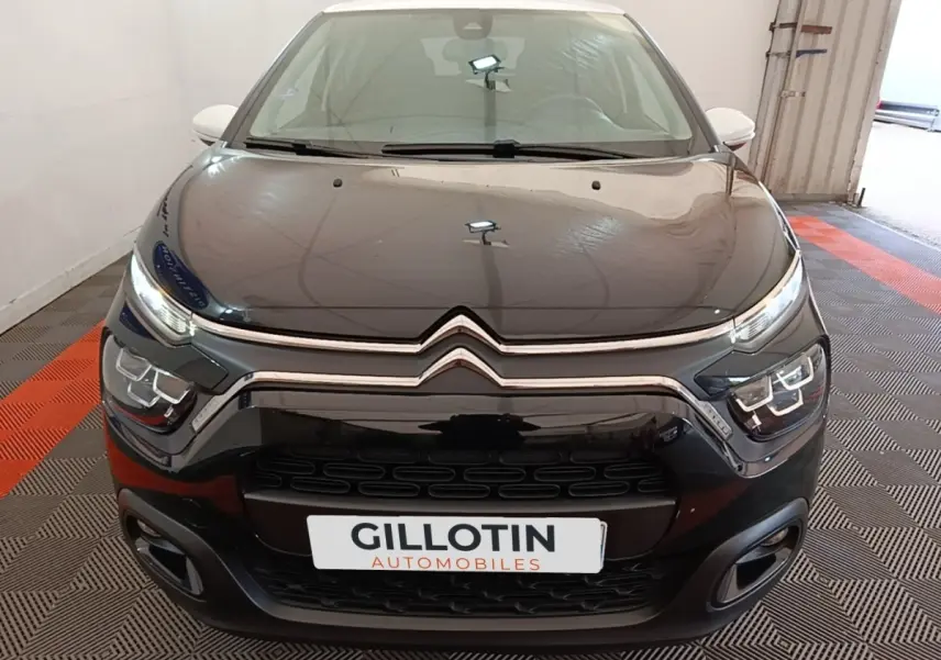 Vue frontale d'une Citroën C3 noire 2022 avec phares LED et calandre chromée dans un garage.