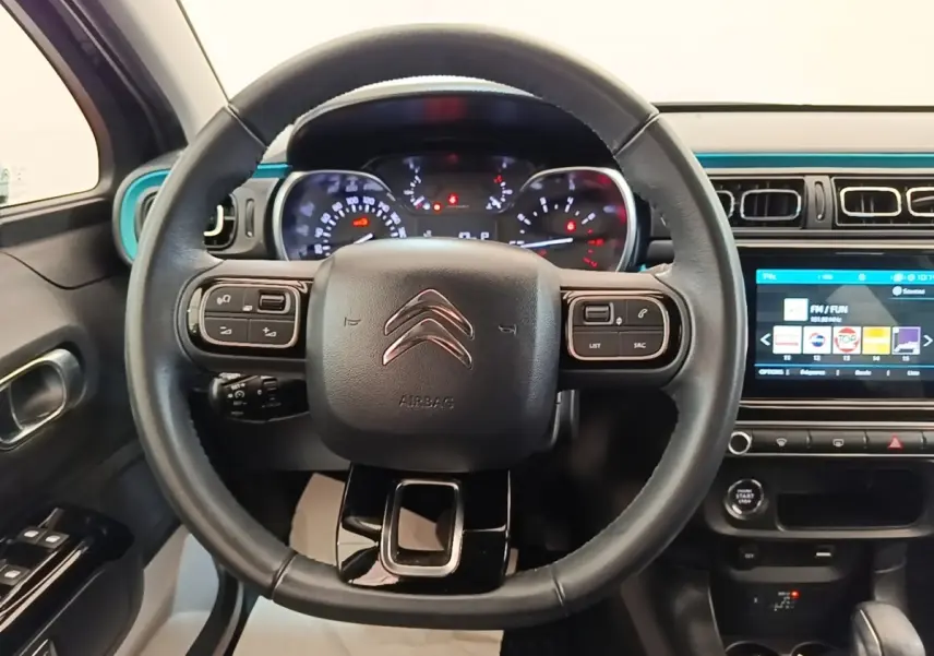 Vue intérieure centrée sur le volant cuir noir de la Citroën C3 2022 avec tableau de bord et écran tactile.