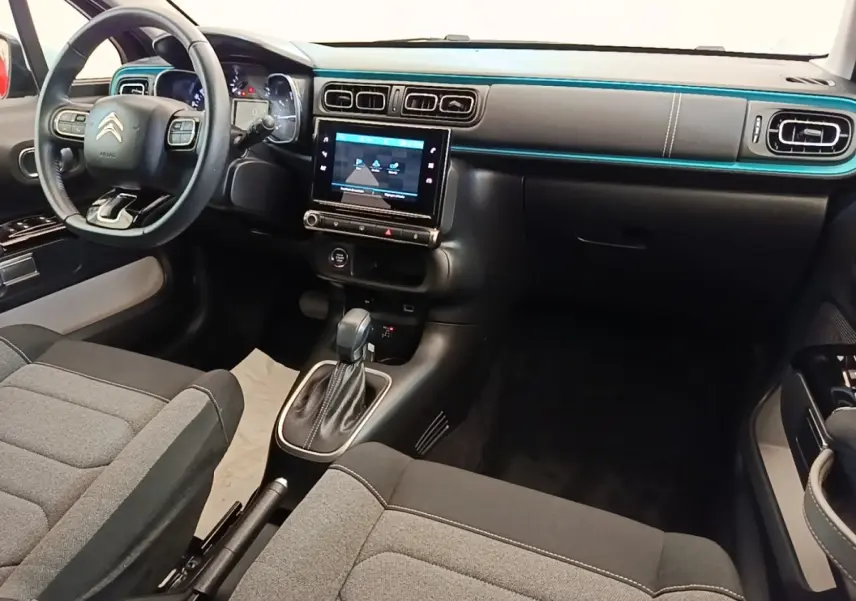 Vue intérieure avant droite du tableau de bord noir et gris de la Citroën C3 avec écran tactile et volant cuir.