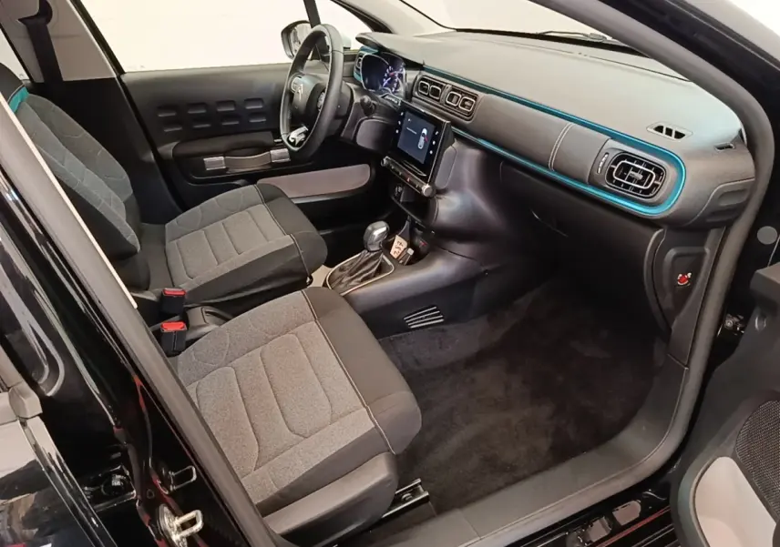 Intérieur avant droit d’une Citroën C3 noire 2022, montrant sièges gris, tableau de bord avec écran tactile et volant multifonctions.