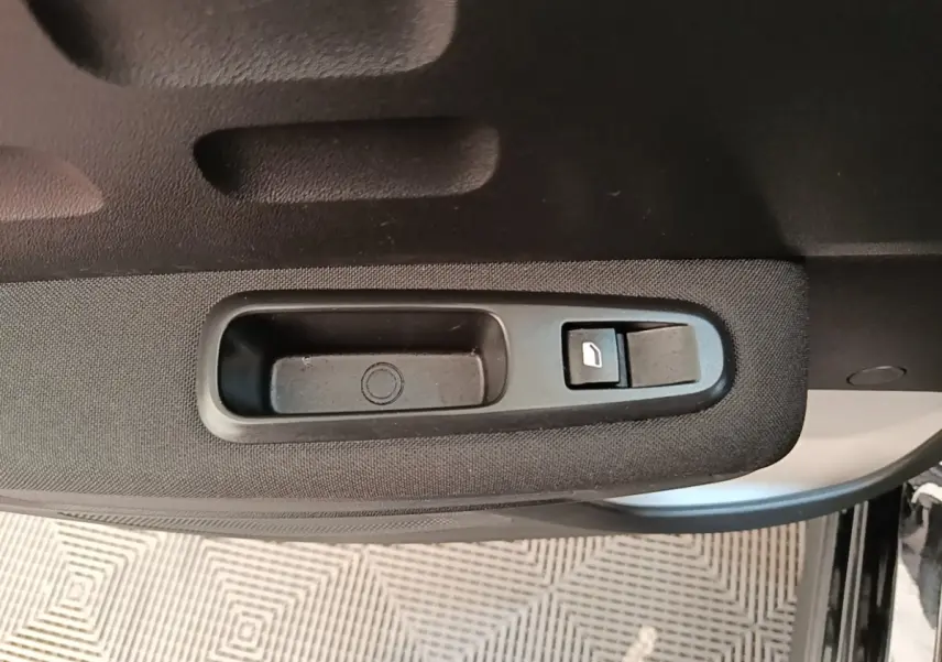 Gros plan sur la commande de lève-vitre côté gauche de la porte d’une Citroën C3 noire 2022.