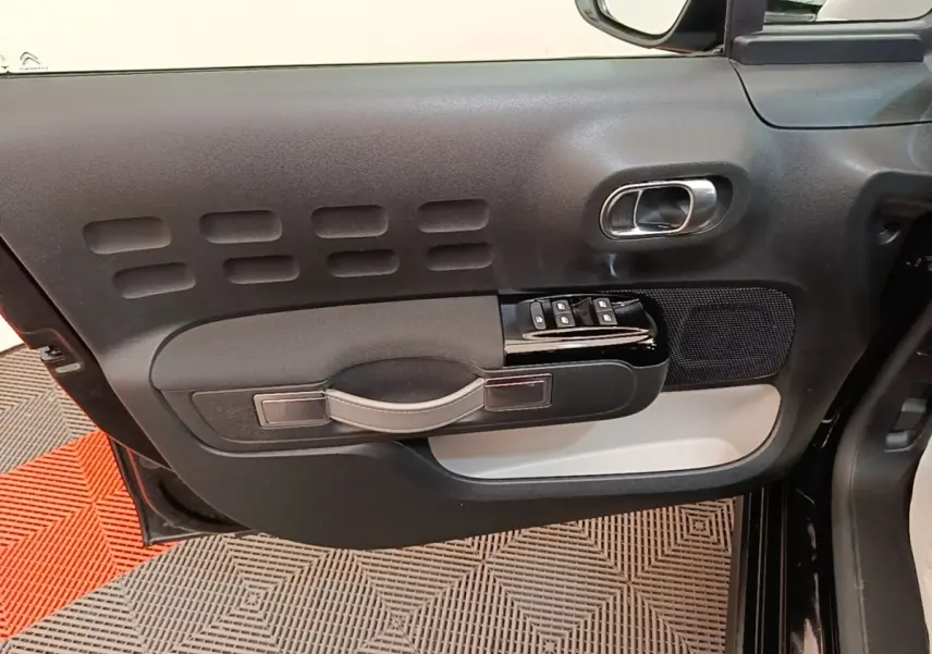 Vue rapprochée de la porte avant gauche noire de la Citroën C3 2022, avec commandes de vitres et poignée intégrée.