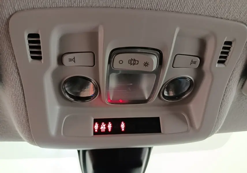 Gros plan sur la console de plafonnier avec éclairages et indicateurs de ceinture dans une Citroën C3 noire 2022.