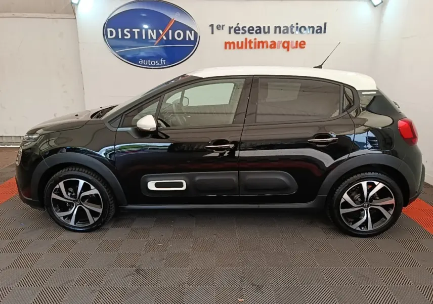 Profil droit d'une Citroën C3 PureTech 110 noire avec toit blanc et protections latérales caractéristiques.