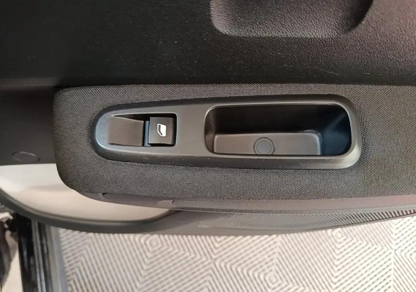 Gros plan sur la poignée intérieure et le bouton de lève-vitre côté gauche d’une Citroën C3 noire.