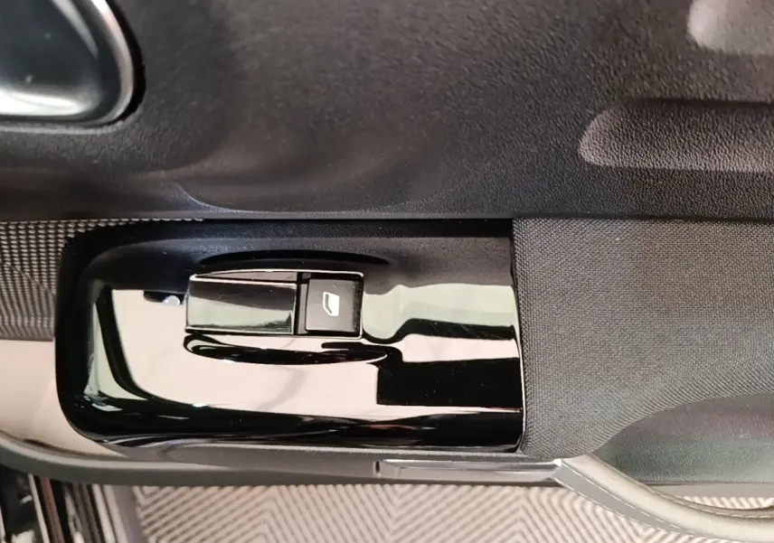 Gros plan sur la commande de lève-vitre côté conducteur de la Citroën C3 noire, finition Shine Pack 2022.