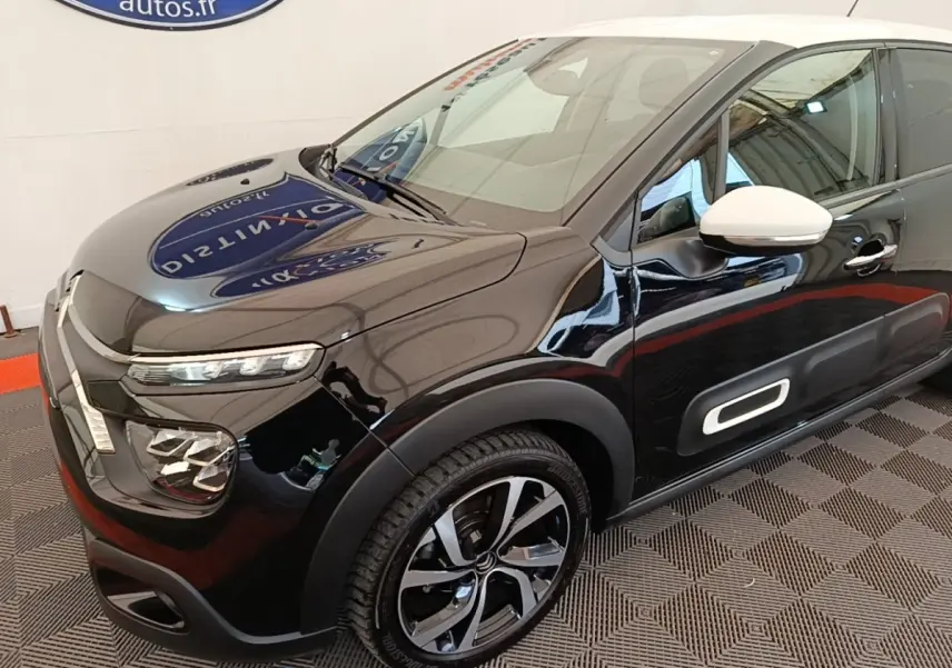 Vue 3/4 avant droit d'une Citroën C3 noire avec rétro blanc et jantes alliage distinctives.