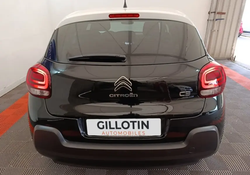 Vue arrière d'une Citroën C3 noire 2022 avec feux arrière LED allumés dans un garage fermé.