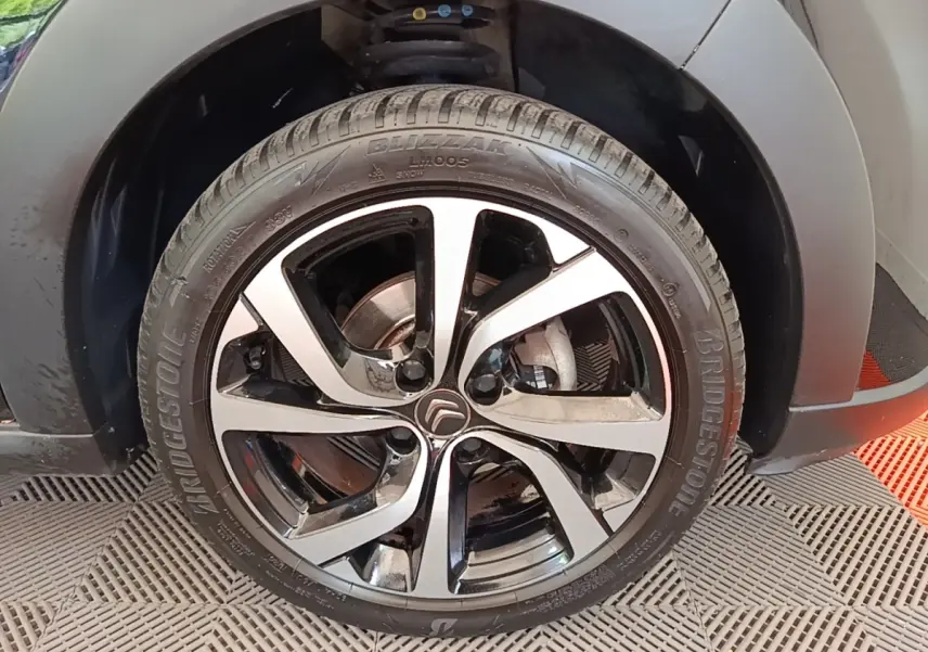 Gros plan sur la roue avant droite noire avec jante alliage bicolore du Citroën C3 PureTech 110 2022.