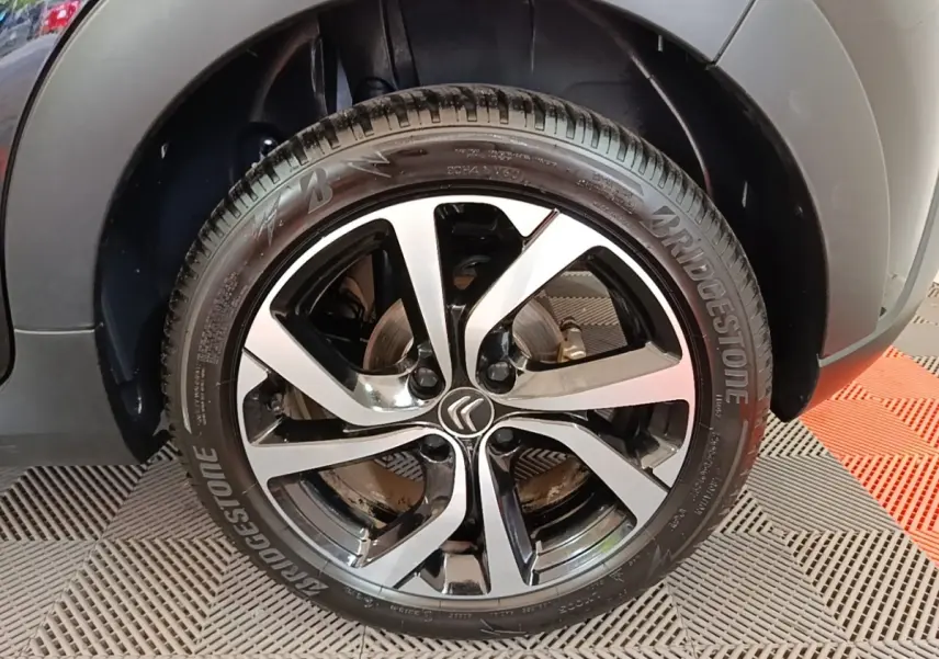 Gros plan sur la roue avant droite noire et argentée d'une Citroën C3 2022, avec logo Citroën central visible.