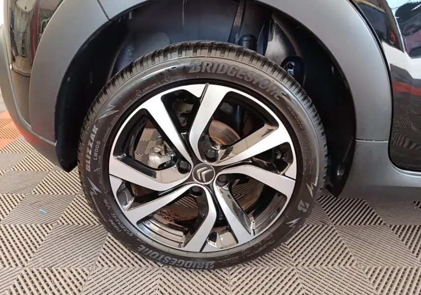 Gros plan sur la roue avant gauche noire d'une Citroën C3 2022 avec jante alliage et pneu Bridgestone.