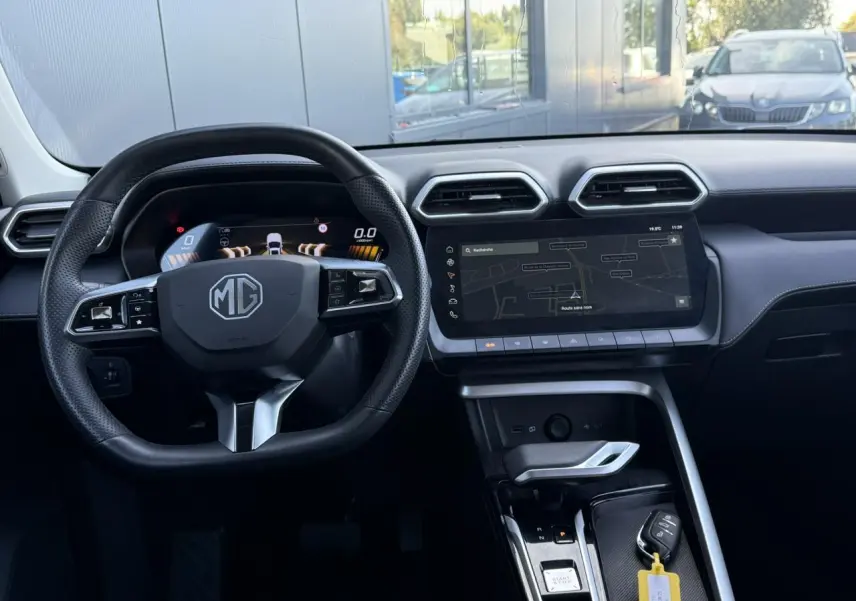 Vue intérieure frontale du poste de conduite du MG ZS 1.5 Hybrid+ 197 Luxury avec volant cuir noir et écran tactile 12,3 pouces.