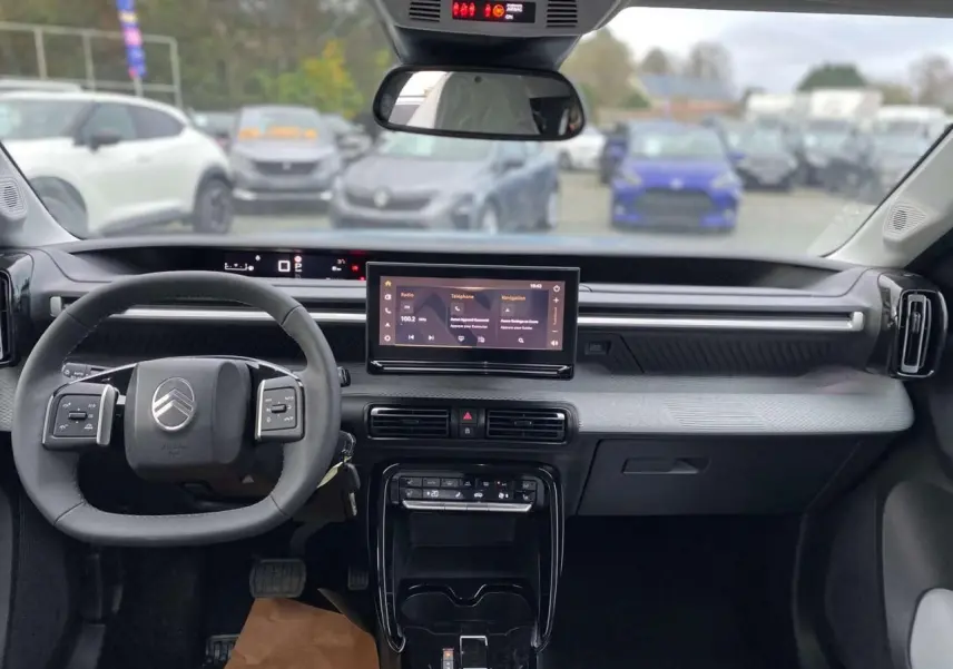Vue intérieure du tableau de bord et volant noir du Citroën C3 Aircross 2025 avec écran tactile central et affichage numérique.
