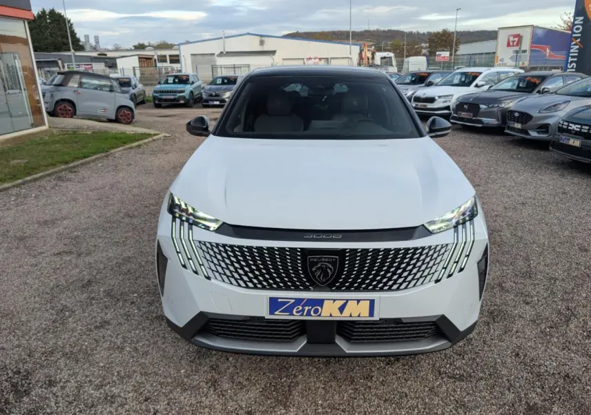 Vue avant d'un Peugeot 3008 blanc 2025 avec calandre noire à motif géométrique et feux LED griffés distinctifs.