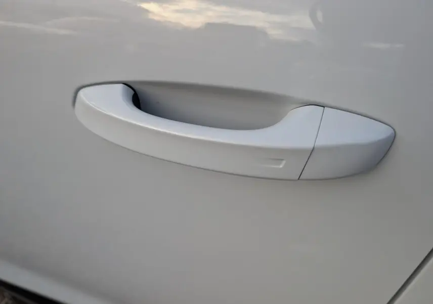 Poignée de porte blanche en gros plan sur la porte côté gauche du Peugeot 3008 Hybrid GT 2025.