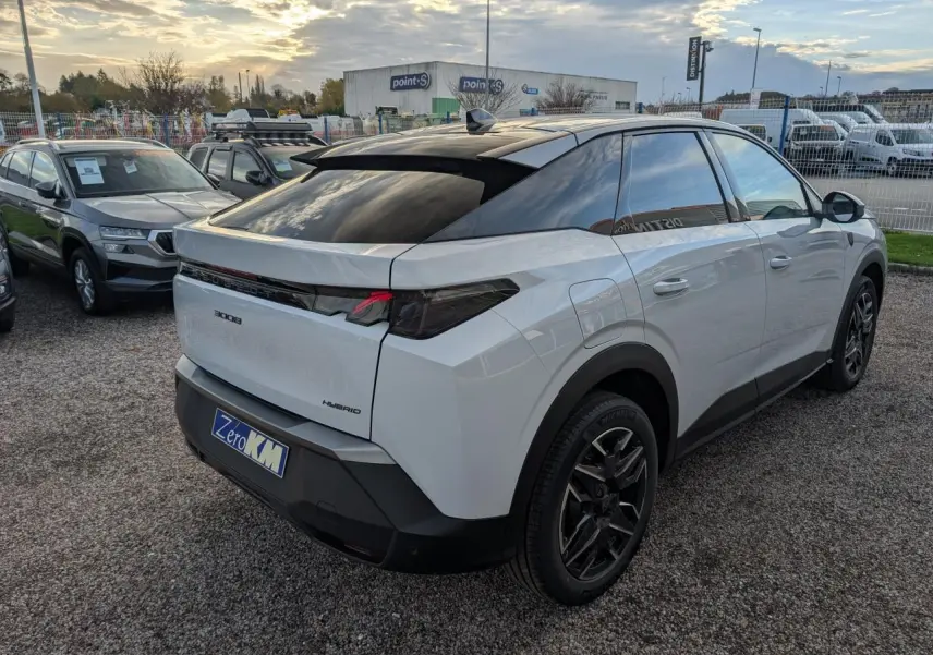 Vue 3/4 arrière droite d'un Peugeot 3008 blanc hybride avec jantes noires et bandeau noir laqué entre feux arrière.