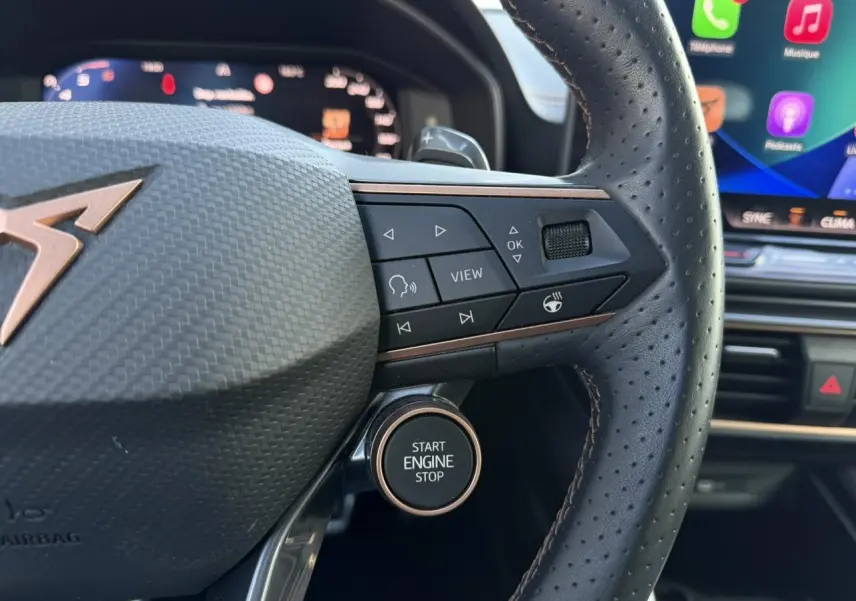 Gros plan sur le volant cuir perforé du CUPRA Formentor bleu Fjord, avec boutons multifonctions et bouton Start Engine Stop.