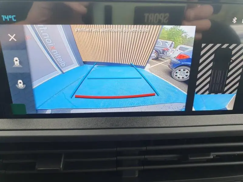 Vue caméra de recul du Citroën Jumpy gris titane métal, montrant l’arrière et l’espace de stationnement bleu.