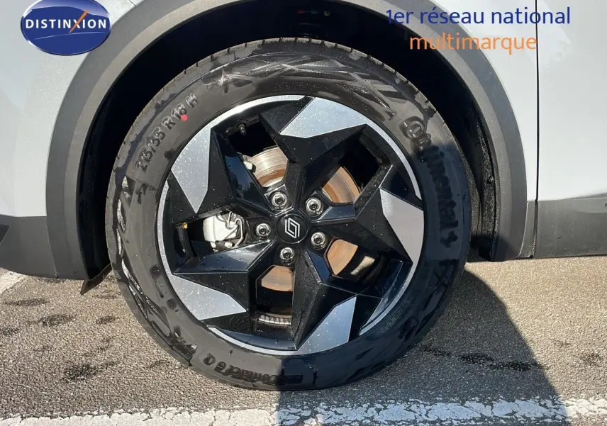Gros plan sur la roue avant gauche du Renault Captur gris Rafale métal avec jante noire et argentée design géométrique.