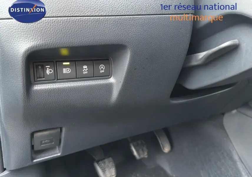 Vue intérieure sur les commandes de réglage des phares et aides à la conduite côté gauche d'une Toyota Aygo X noire 2025.