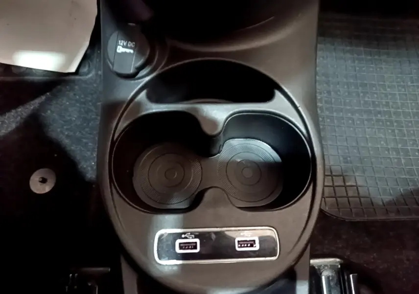 Gros plan sur les porte-gobelets et les ports USB avant de la Fiat 500 Hybrid blanche de 2021.