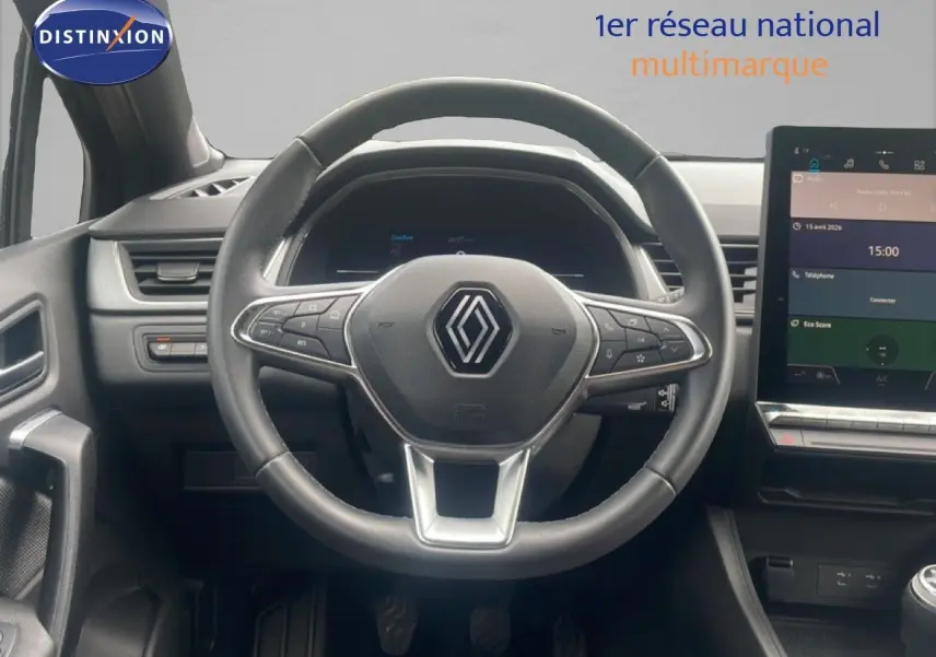 Vue intérieure centrée sur le volant Renault Captur 2025, avec écran tactile et commandes au volant visibles.