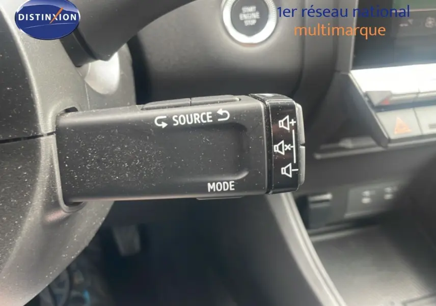 Gros plan sur la commande audio au volant du Renault Captur 2025 noir étoile métal avec toit gris, intérieur moderne.