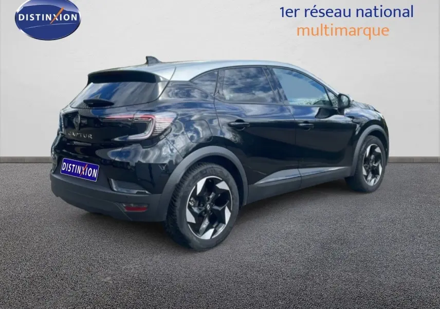 Vue 3/4 arrière droite d'un Renault Captur noir étoile métal avec toit gris, jantes bi-ton et vitres teintées.