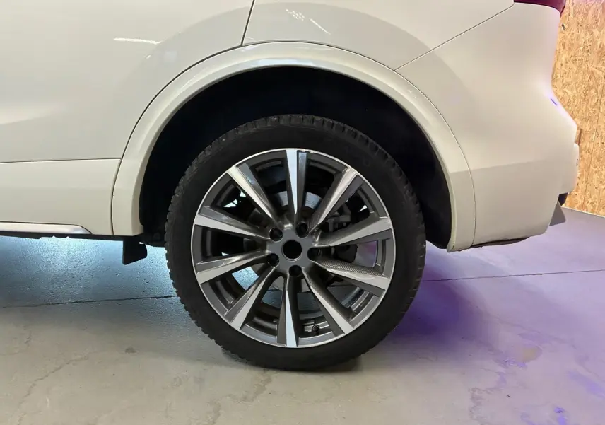 Gros plan sur la roue arrière droite du Nissan Qashqai blanc, mettant en valeur la jante alliage moderne.