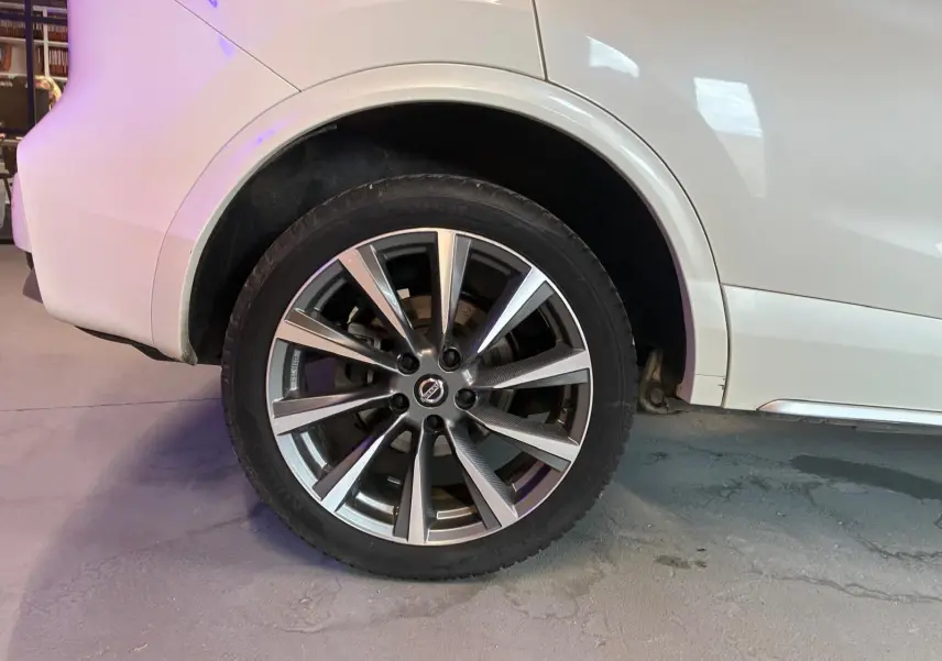 Gros plan sur la roue arrière droite d’un Nissan Qashqai blanc, mettant en valeur la jante alliage moderne.