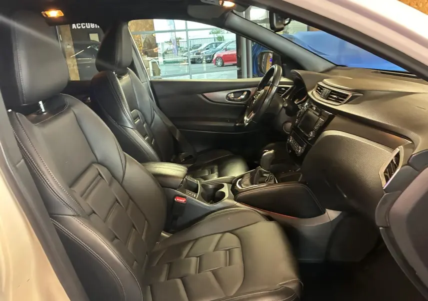 Intérieur noir cuir du Nissan Qashqai 1.5 BlueDCI 115 Tekna+, vue côté conducteur avec tableau de bord et console centrale.