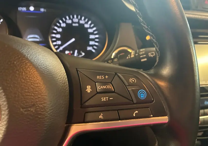 Gros plan sur le volant noir du Nissan Qashqai 1.5 BlueDCI 2021, montrant les commandes de régulateur de vitesse et téléphone.
