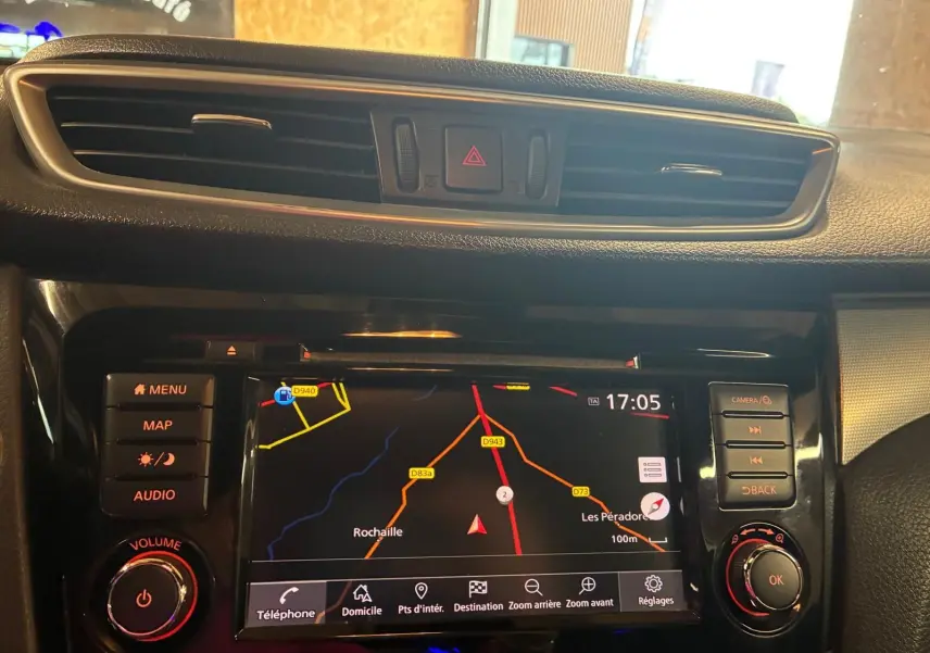 Vue rapprochée de l’écran GPS central du Nissan Qashqai blanc 2021, avec commandes et tableau de bord noir.