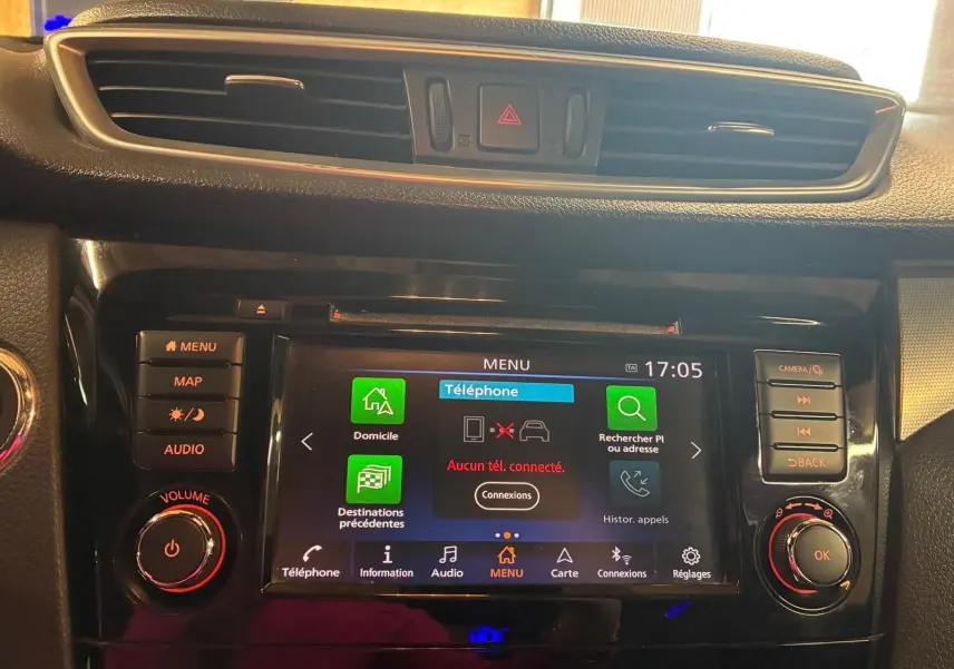 Vue rapprochée de la console centrale noire du Nissan Qashqai 1.5 BluedCi 115 Tekna+ avec écran tactile et commandes lumineuses.