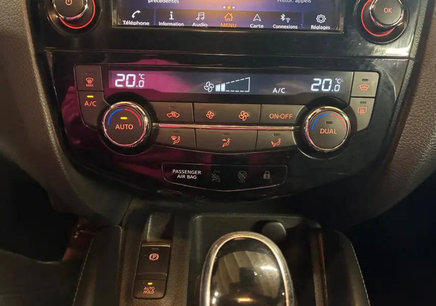 Vue rapprochée du tableau de bord du Nissan Qashqai 1.5 BlueDCI 115 Tekna+ 2021, avec commandes climatisation et boîte auto.