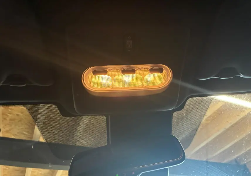 Plafonnier intérieur allumé vu de face dans un Nissan Qashqai blanc 2021, avec rétroviseur central et pare-brise partiellement visible.