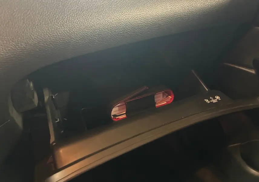 Gros plan sur la boîte à gants ouverte du Nissan Qashqai blanc 2021, montrant un carnet rouge à l'intérieur.