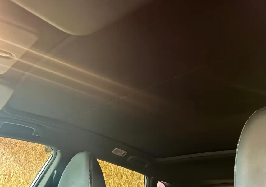 Vue intérieure du toit panoramique et des appuie-têtes avant en cuir noir du Nissan Qashqai blanc 2021.