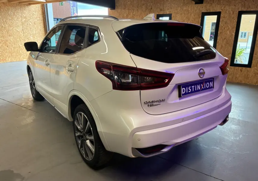 Vue 3/4 arrière droite du Nissan Qashqai blanc 1.5 BlueDCI Tekna+ 2021 avec feux arrière LED et toit noir.