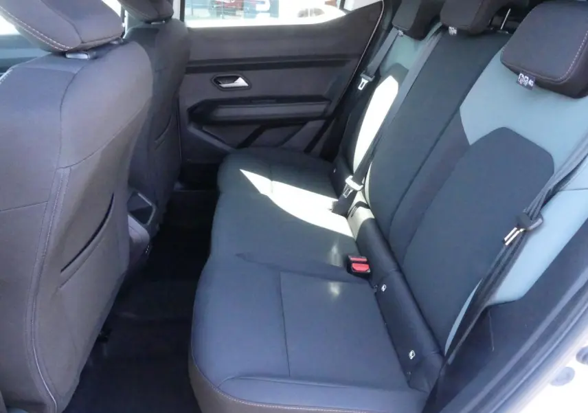 Vue intérieure côté droit sur la banquette arrière noire et grise du Dacia Duster 1.6 Hybrid blanc Glacier 2025.