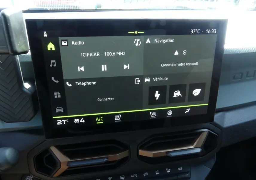 Écran tactile 10 pouces du tableau de bord du Dacia Duster blanc avec aérateurs brun cuivré visibles en partie basse.