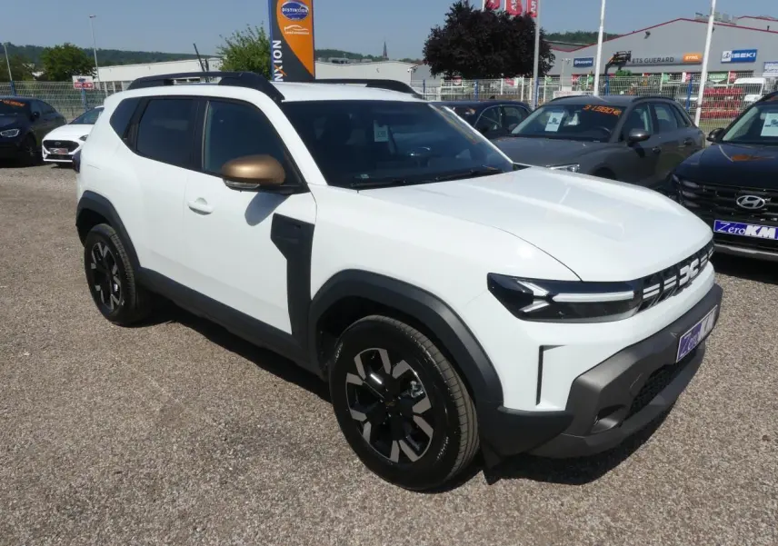 Vue 3/4 avant droite d'un Dacia Duster blanc avec coques de rétroviseurs brun cuivré et jantes alliage noires.