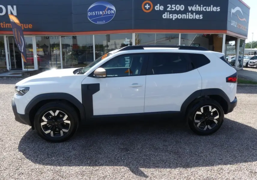 Profil côté gauche d'un Dacia Duster blanc Glacier 2025 avec jantes alliage et détails noirs contrastants.