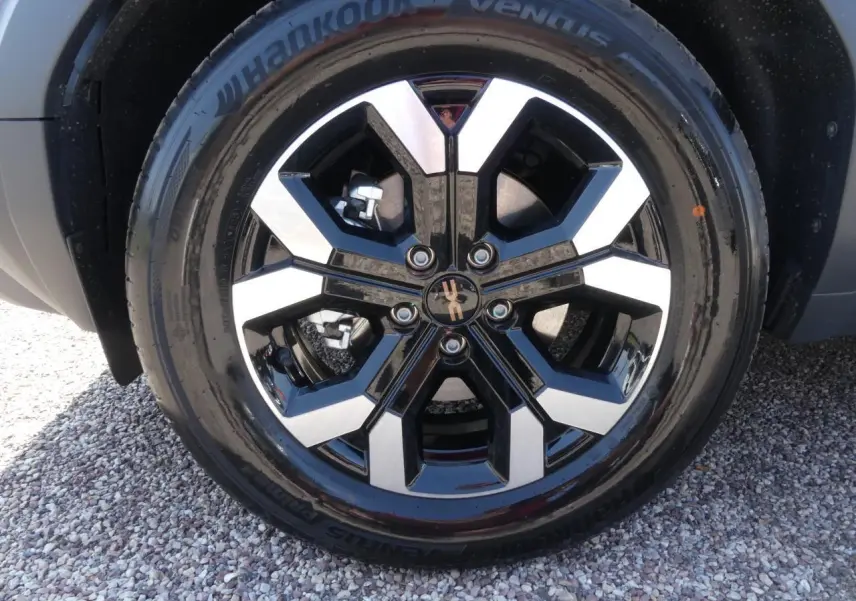 Gros plan sur la jante alliage 17 pouces bicolore noir et argent du Dacia Duster blanc Glacier 2025.