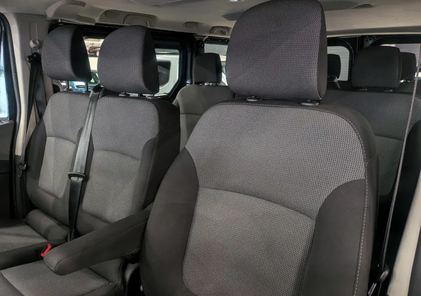 Vue intérieure rapprochée des sièges en tissu gris foncé du Renault Trafic Combi L2 9 places, version 2023.