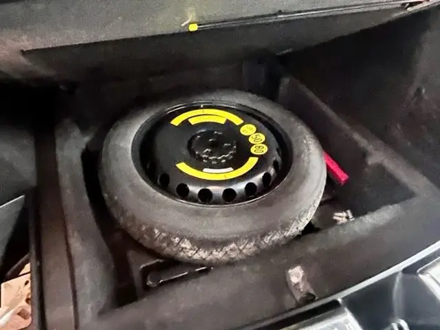 Roue de secours compacte avec marquages jaunes dans le coffre d'un Mercedes GLE Coupe 350 d 2016 noir.