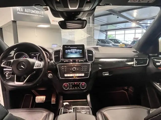 Intérieur du Mercedes GLE Coupe 350 d 2016, vue frontale du tableau de bord avec écran central et finitions noires brillantes.