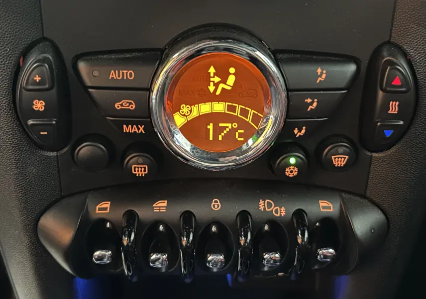 Gros plan sur la console centrale de la MINI Cabriolet rouge, affichant la température à 17°C et les commandes de climatisation.