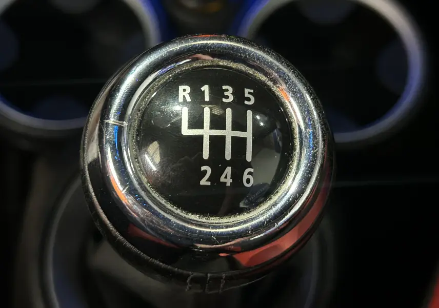 Gros plan sur le pommeau de la boîte manuelle 6 vitesses d'une MINI Cabriolet Cooper S rouge de 2012.