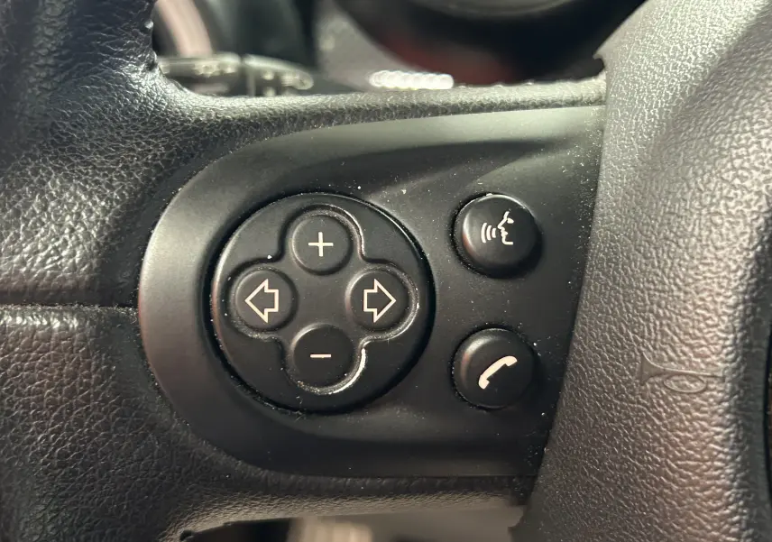 Gros plan sur la commande d’essuie-glace à gauche du volant dans l’habitacle rouge d’une MINI Cabriolet rouge de 2012.